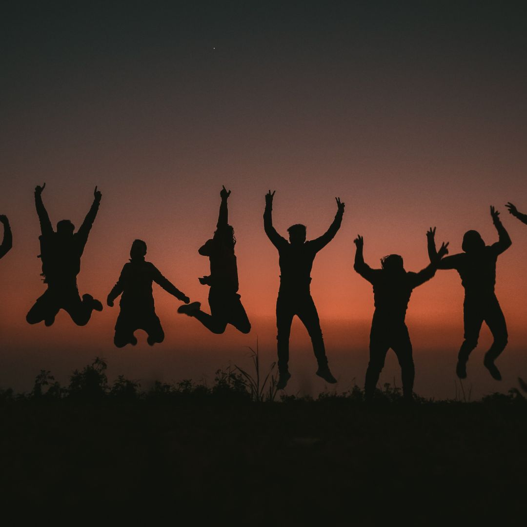 Team jumping at sunset